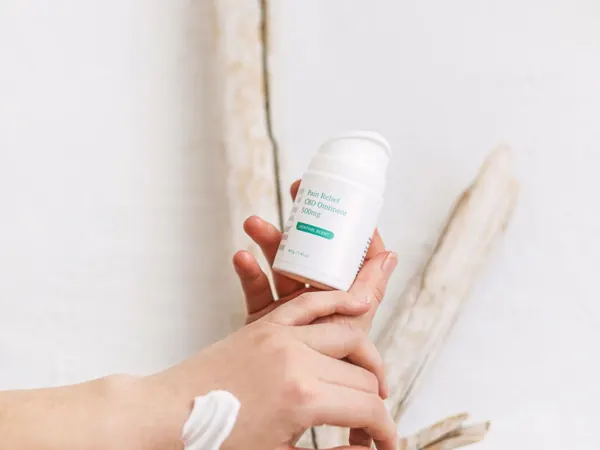Hands holding a bottle of skincare cream