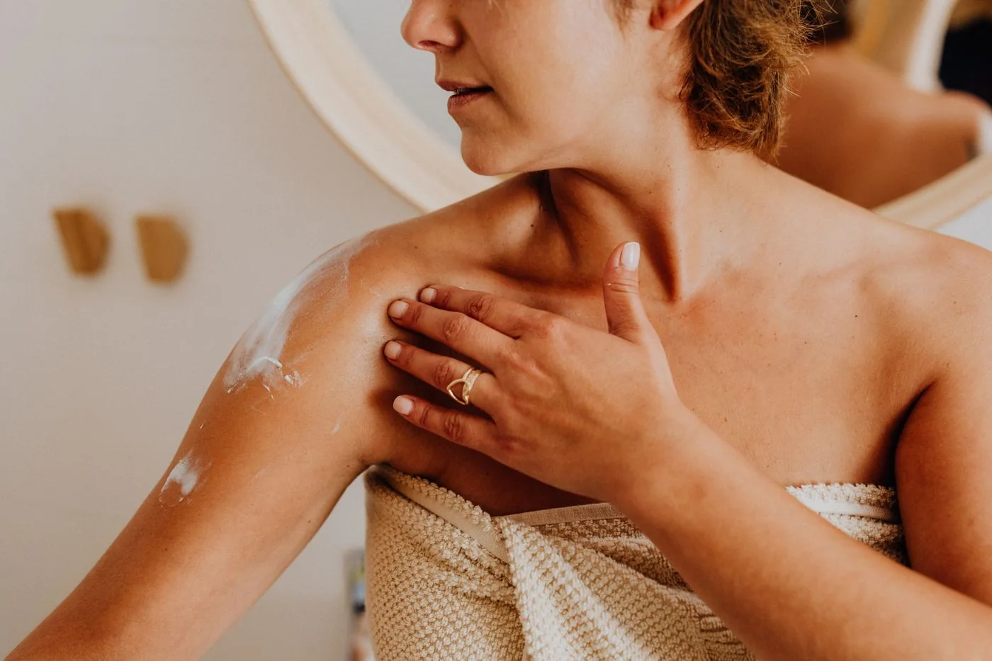Woman applying body lotion during her care routine