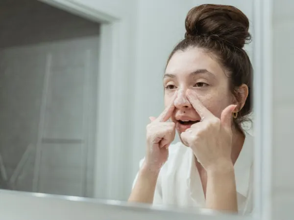 Woman washing her face at a bathroom sink