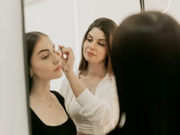 Makeup being applied in front of a vanity mirror
