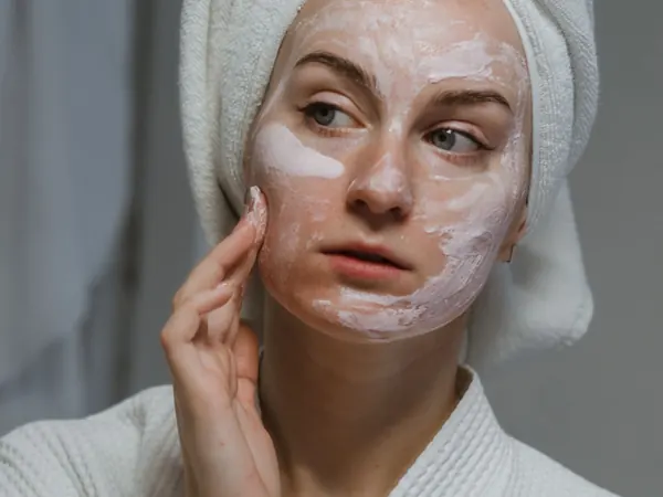 Woman applying face cream during a bathroom routine