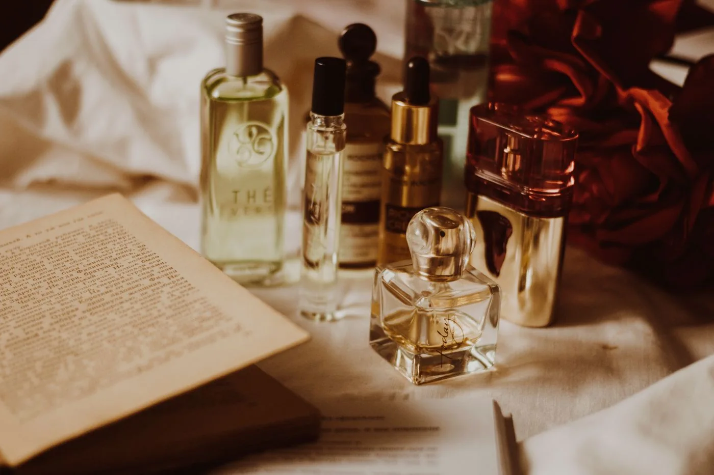 Perfume bottles and an open book on a table