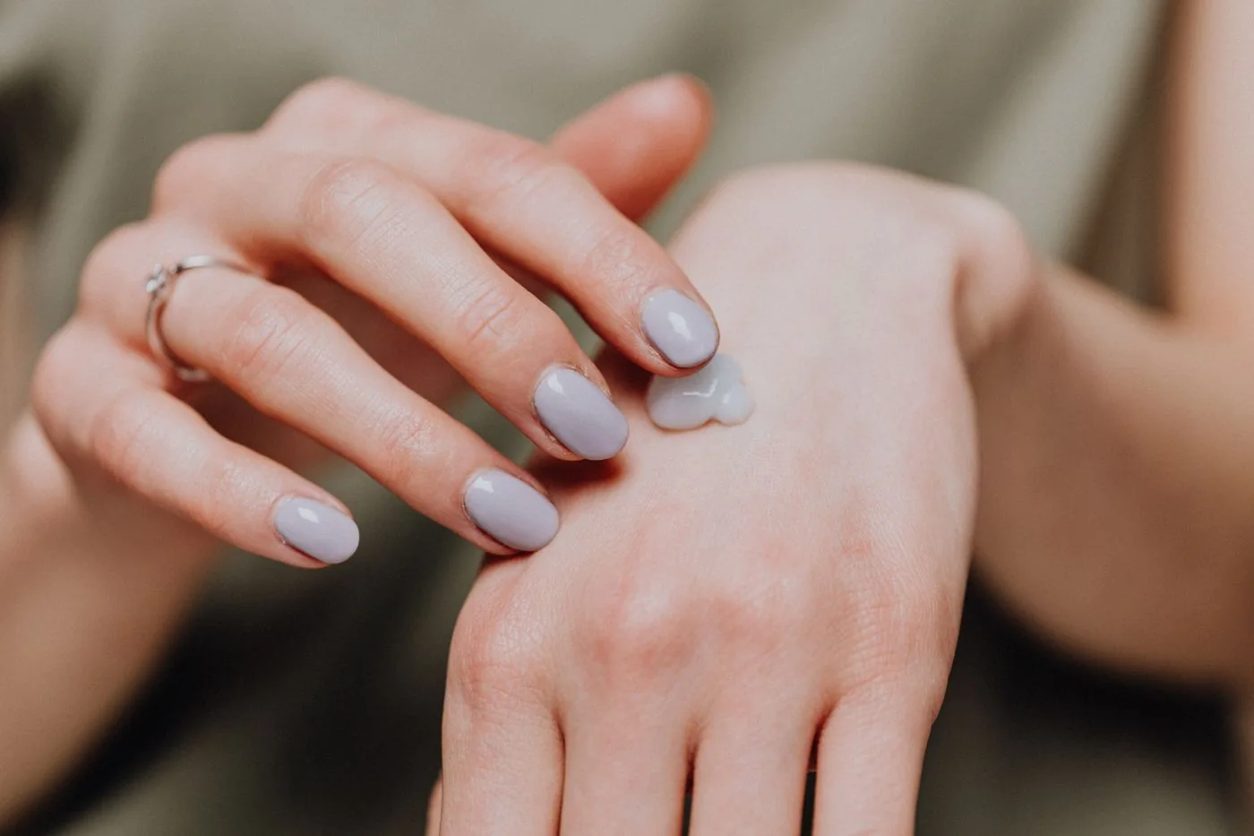 Hands applying cream while wearing a casual shirt