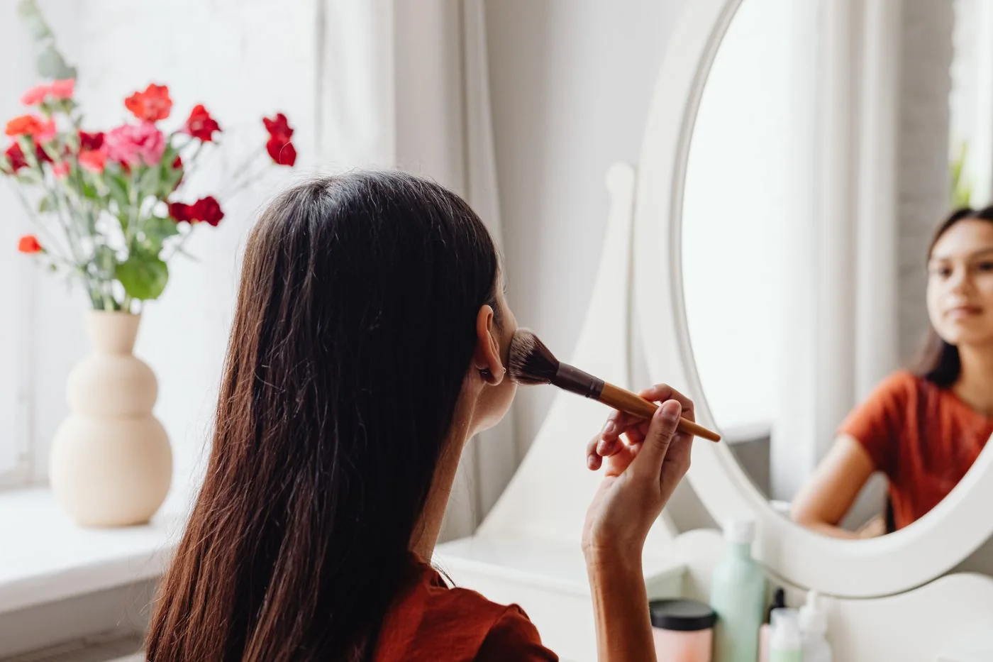 Woman doing makeup at a dressing table