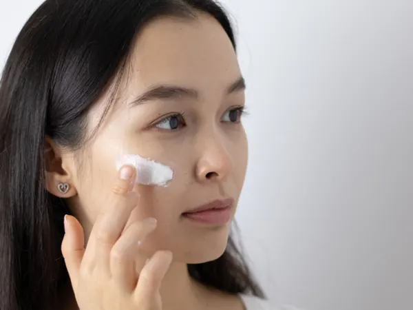 Woman applying a skincare product to her face