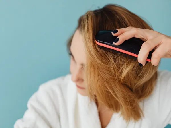 Woman in a bathrobe brushing her hair
