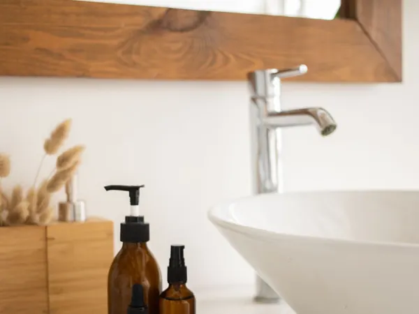 Skincare bottles arranged beside a bathroom sink