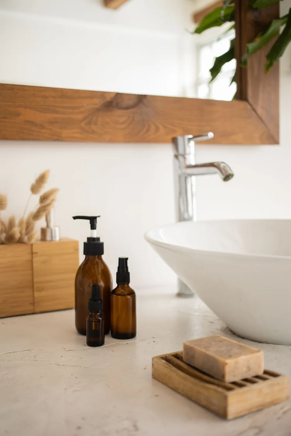 Skincare bottles arranged beside a bathroom sink